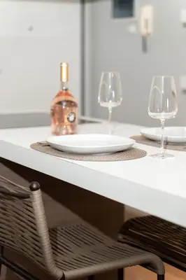 a table with two wine glasses and a bottle on it at Blue Avra Apartment by A&D Properties in Porto Rafti