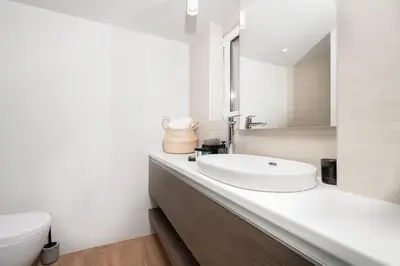 a white bathroom with a sink and a toilet at Blue Avra Apartment by A&D Properties in Porto Rafti