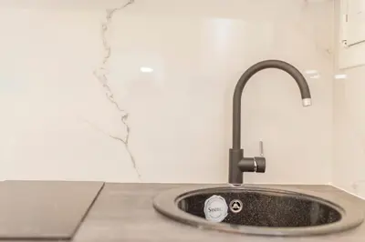 a kitchen sink with a faucet on a counter at Lovely studio 1' from Attiki metro station in Athens