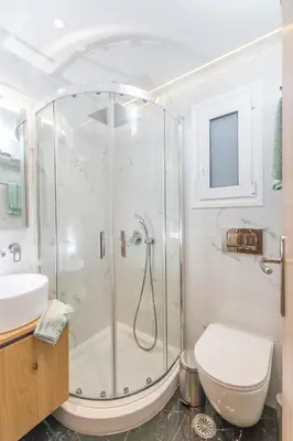 a bathroom with a shower with a toilet and a sink at Lovely studio 1' from Attiki metro station in Athens