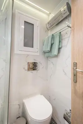a small bathroom with a toilet and a mirror at Lovely studio 1' from Attiki metro station in Athens