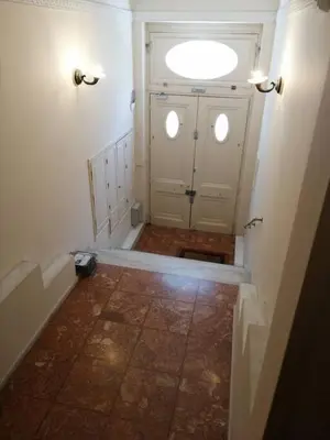 a hallway with a door with a window and a tile floor at Elegant apartment under the Acropolis in Athens