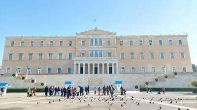 a group of people standing in front of a building with birds at Elegant apartment under the Acropolis in Athens