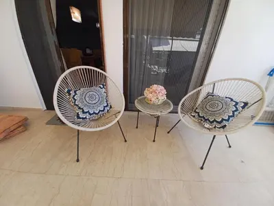 three chairs and a table with a vase of flowers at ZEN Neapoli Penthouse Apartment in Athens