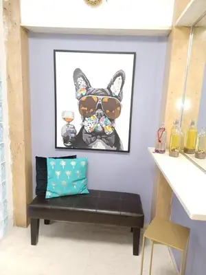 a bench in a room with a painting of a french bulldog at ZEN Neapoli Penthouse Apartment in Athens