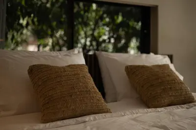 a bed with two brown pillows on it at Vouliagmeni Apartments 18 in Athens