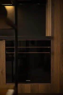 a black microwave oven in a wooden cabinet at Vouliagmeni Apartments 18 in Athens