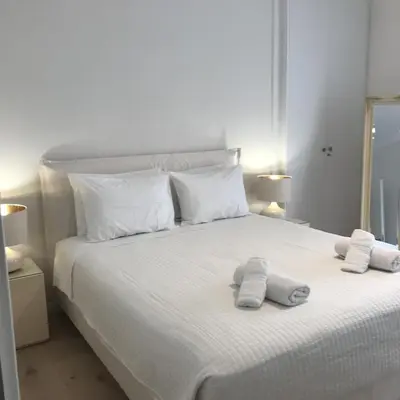 a bedroom with a white bed with towels on it at Acropolis Flat in Athens