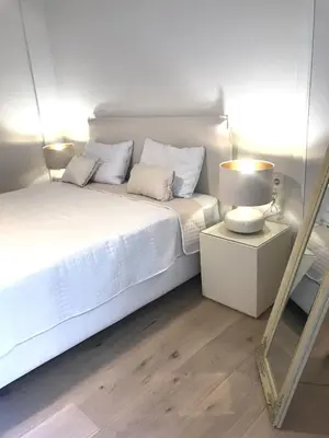 a white bedroom with a bed and a mirror at Acropolis Flat in Athens