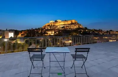 a table and two chairs on a patio with a mountain at Acropolis Flat in Athens