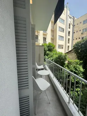 a balcony with a white chair and a table at Acropolis Flat in Athens