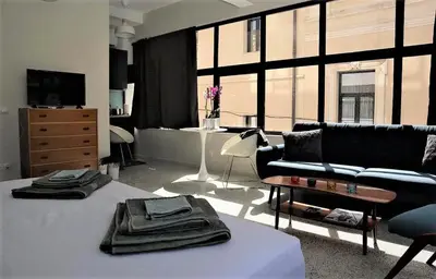 a living room with a black couch and a table at Central urban studio A in Athens