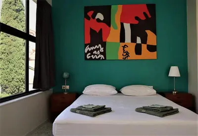 a bedroom with a white bed with a green wall at Central urban studio A in Athens