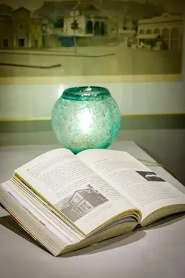 an open book on a table next to a vase at Urban Tales in Athens