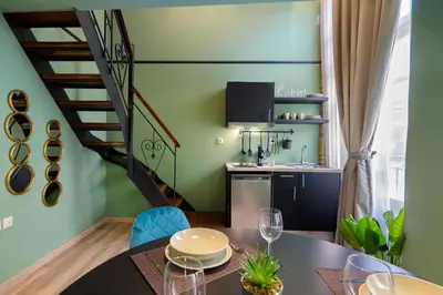 a kitchen and dining room with a table and a staircase at Urban Tales in Athens