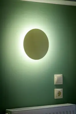 a light on a green wall with a moon at Urban Tales in Athens