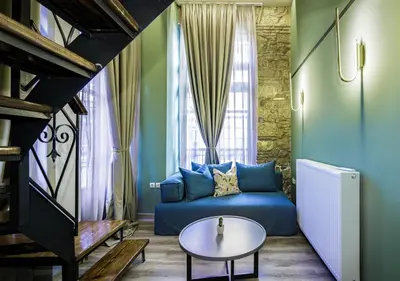 a living room with a blue couch and a table at Urban Tales in Athens