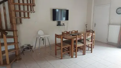 a dining room with a table and chairs and a television at Anna's House in Anavissos