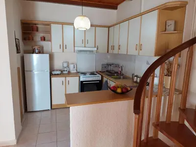 a kitchen with white appliances and a bowl of fruit on a counter at Anna's House in Anavissos