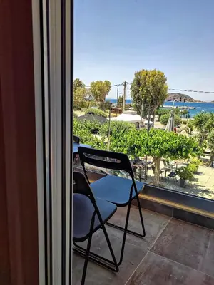 a chair sitting on a balcony with a view of the ocean at Seaview-Apartments in Palaiá Fókaia