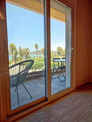 a sliding glass door with a view of a patio at Seaview-Apartments in Palaiá Fókaia