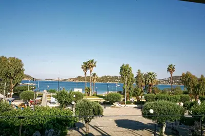 a view of a park with palm trees and a body of water at Seaview-Apartments in Palaiá Fókaia