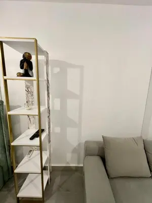 a living room with a couch and a shelf with a teddy bear at New apartment at Athenian Riviera in Athens