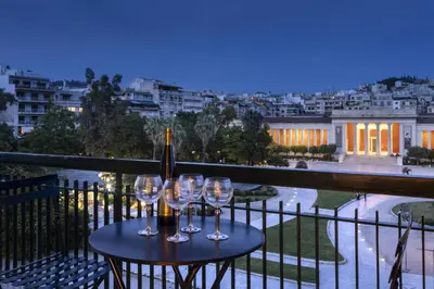 a table with wine glasses on a balcony at A Truly WOW Experience for Every Guest. THE place in Athens