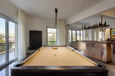 a pool table in the middle of a room with a pool table at A Truly WOW Experience for Every Guest. THE place in Athens