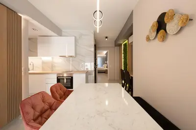 a kitchen with a white counter and two chairs at LUX&EASY Athens Downtown Residences in Athens
