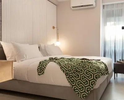 a bedroom with a large bed with a black and white blanket at LUX&EASY Athens Downtown Residences in Athens