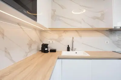 a kitchen with a white sink and marble walls at LUX&EASY Athens Downtown Residences in Athens