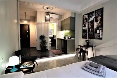 a room with a bed and a kitchen and a living room at Central urban studio B in Athens