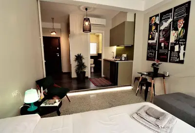 a hotel room with a bed and a living room at Central urban studio B in Athens