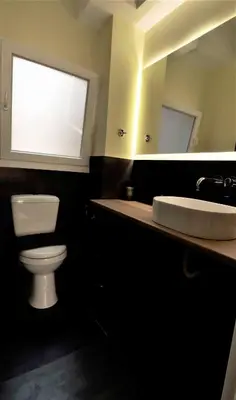 a bathroom with a toilet and a sink and a mirror at Central urban studio B in Athens