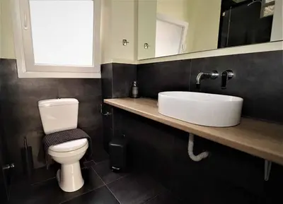 a bathroom with a white toilet and a sink at Central urban studio B in Athens