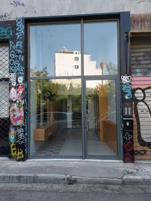 a window of a store with graffiti on it at Central urban studio B in Athens