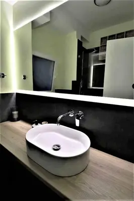 a bathroom with a white sink and a mirror at Central urban studio B in Athens