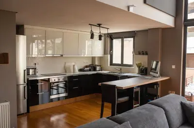a kitchen with a couch and a table in a room at Minimal New Loft next to Subway in Athens