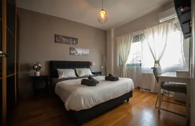 a bedroom with a bed and a desk and a window at Minimal New Loft next to Subway in Athens