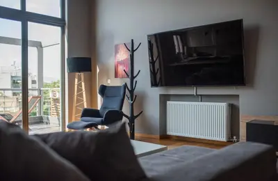 a living room with a couch and a tv at Minimal New Loft next to Subway in Athens