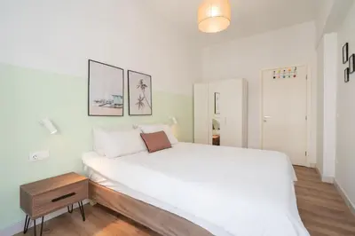 a bedroom with a large white bed and a wooden table at ☆Kalimarmaro 3BD Apt For Max Fun & Comfortability☆ in Athens