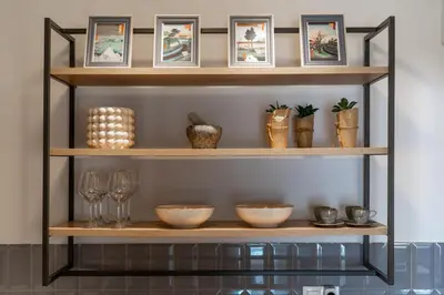 a shelf with bowls and wine glasses on it at ☆Kalimarmaro 3BD Apt For Max Fun & Comfortability☆ in Athens