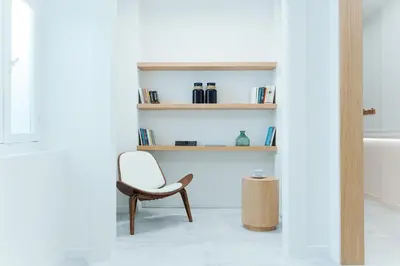 a white room with a chair and a bath tub at Agora Athens Suites in Athens