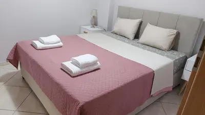 a large bed with two towels on top of it at Gianni & Sophia airport house in Artemida