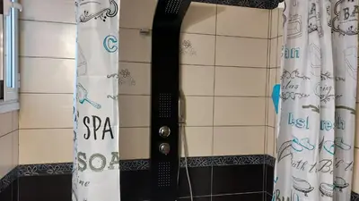 a shower with a black shower curtain in a bathroom at Gianni & Sophia airport house in Artemida