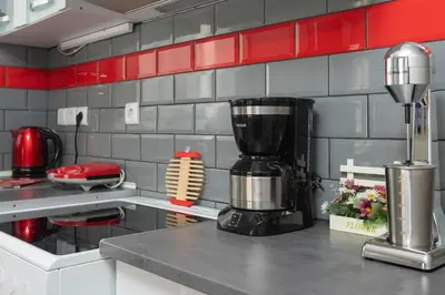 a kitchen with a red and gray tiled wall at The Athenian Penthouse Residence in Athens