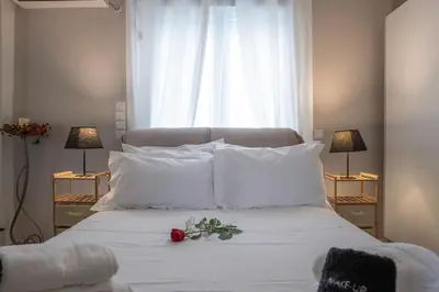 a bed with white pillows and a red rose on it at The Athenian Penthouse Residence in Athens