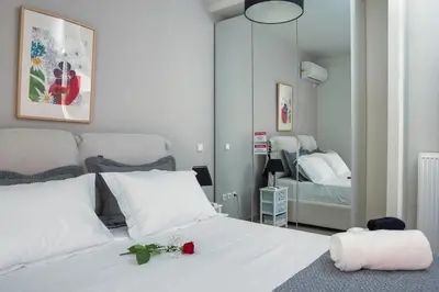 a bedroom with a white bed and a mirror at The Athenian Penthouse Residence in Athens
