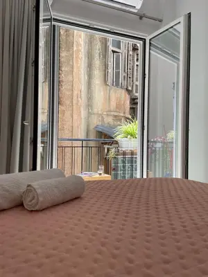 a bed in a room with a large window at mosaic art apartment in plaka in Athens